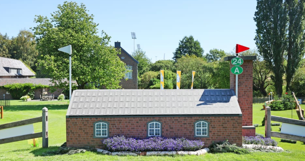 Sprung 24 ABC SAP Village – hier wartet ein Häuschen auf einer Anhöhe darauf, gesprungen zu werden. Danach geht es in einer Rechtswendung bergab über zwei offene Ecken.
